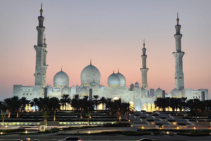 Experience the stunning beauty of Sheikh Zayed Grand Mosque as it emerges against a dusky sky showcasing its grand architecture and exquisite details inviting reflection and appreciation for cultural harmony.